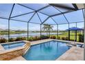 Enjoy this relaxing screened-in pool with a luxurious hot tub and a serene lake view at 12564 Night View Dr, Sarasota, FL 34238