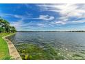 Scenic view of the lake with clear, calm water and a vibrant blue sky with wispy clouds at 138 Toscavilla Blvd, Nokomis, FL 34275