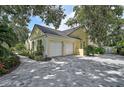 Spacious three-car garage with a brick driveway and well-maintained landscaping at 140 Sugar Mill Dr, Osprey, FL 34229
