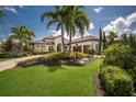 A beautiful single-story home featuring lush landscaping, a tile roof, and a paver driveway at 16531 Kendleshire Ter, Lakewood Ranch, FL 34202