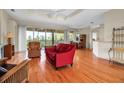 Spacious living room featuring wood floors, tray ceilings, and sliding doors opening to a scenic balcony at 2048 Larson St, Englewood, FL 34223