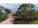 Inviting home with a red tile roof, lush landscaping and a brick driveway at 205 Sugarloaf Dr, Nokomis, FL 34275