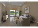 Cozy living room with a comfortable couch, stylish decor, and sliding glass doors to the backyard at 2148 Date Palm Way, Venice, FL 34292