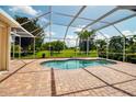 Beautiful backyard pool area surrounded by a screened enclosure with views of the green lawn at 2148 Date Palm Way, Venice, FL 34292