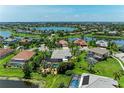 Scenic aerial shot of luxurious homes with screened pools in a lakeside community at 303 Cockle Shell Loop, Apollo Beach, FL 33572