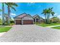 Charming home showcasing a spacious paver driveway and a manicured front lawn at 303 Cockle Shell Loop, Apollo Beach, FL 33572