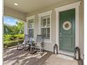 Inviting front porch with rocking chairs and a decorative wreath on the door at 3344 Anchor Bay Trl, Bradenton, FL 34211