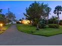 Well-manicured front yard with beautiful landscaping, mature trees, and a lighted walkway leading to the home's entrance at 355 Shore Dr, Ellenton, FL 34222