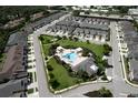 Aerial view of the community pool with cabanas, palm trees, lush landscaping and plenty of lounge chairs at 3681 Divot Ln, Sarasota, FL 34232