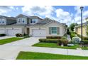 Inviting exterior of a charming home with a two-car garage, lush landscaping, and a well-maintained lawn at 3681 Divot Ln, Sarasota, FL 34232