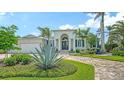 Stunning front view of property, showcasing lush landscape, circular driveway and entryway at 413 Partridge Cir, Sarasota, FL 34236
