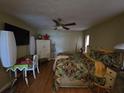 Bedroom featuring a ceiling fan, television, wood floors, and ample natural light at 4343 Arrow Ave, Sarasota, FL 34232