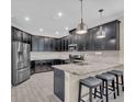 Modern kitchen with stainless steel appliances, granite countertops, an island with seating and dark cabinetry at 5540 Summit Gln, Bradenton, FL 34203