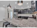 Open concept kitchen with a large granite island with barstool seating, pendant lights, and stainless steel appliances at 5540 Summit Gln, Bradenton, FL 34203