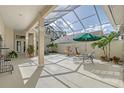 A screened courtyard featuring a fountain, lounge chairs, potted plants and an umbrella for relaxing outdoors at 5839 Los Verdes Ct, Bradenton, FL 34210