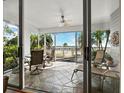 Bright patio features tiled floors, comfortable seating, and scenic views of the waterway and swaying palm trees at 615 Dream Island Pl # 105, Longboat Key, FL 34228