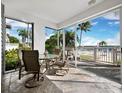 Inviting tiled patio with comfortable seating and picturesque views of the beautiful waterway and palm trees at 615 Dream Island Pl # 105, Longboat Key, FL 34228