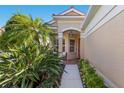 Welcoming front entrance with a covered porch, decorative columns, and manicured landscaping at 7419 Birds Eye Ter, Bradenton, FL 34203
