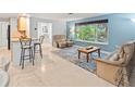 Bright living room featuring a large window, comfortable seating, and seamless flow into the open kitchen space at 760 Azure Rd, Venice, FL 34293