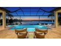 Inviting screened-in pool and spa area with lake view, fire bowls, and comfortable seating for outdoor relaxation and entertaining at 7665 Haddington Cv, Lakewood Ranch, FL 34202