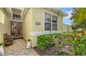 Inviting entryway with beautiful landscaping, a double door entry and tiled walkway at 8183 Nice Way, Sarasota, FL 34238