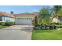 Charming home with a well-manicured lawn, mature trees, and an attached garage at 8183 Nice Way, Sarasota, FL 34238