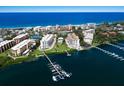 Aerial view of waterfront condominiums with a boat dock on the water and private beach access at 8735 Midnight Pass Rd # 602B, Sarasota, FL 34242