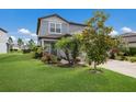 Charming two-story home featuring a well-manicured lawn and beautiful, colorful landscaping at 8985 Royal River Cir, Parrish, FL 34219