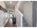 Hallway featuring wood-look flooring, staircase, and view of the entryway with front door at 8985 Royal River Cir, Parrish, FL 34219