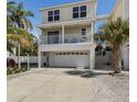 Charming two-story home featuring a spacious garage, balcony, and mature palm trees at 123 52Nd St # B, Bradenton Beach, FL 34217