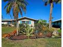 Beautiful Florida home with vibrant tropical landscaping and blue shutters at 134 Gulfview Rd, Punta Gorda, FL 33950