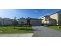 Charming one-story home featuring a manicured lawn, brick driveway, and two car garage at 15127 Oxford Grey Dr, Bradenton, FL 34211