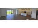 Open-concept living space with hard floors, a modern kitchen, and sliding doors to the backyard at 15127 Oxford Grey Dr, Bradenton, FL 34211