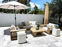 Comfortable outdoor seating area with plush cushions, a large umbrella, and a stylish coffee table on stone pavers at 2217 Muesel St, Sarasota, FL 34237