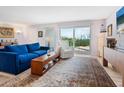 Bright living room featuring comfortable seating, a large rug, and sliding glass doors to the balcony at 2295 Gulf Of Mexico Dr # 64S, Longboat Key, FL 34228