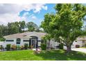 Inviting single-story home boasts mature trees, manicured lawn, and white picket fence at 2381 Appaloosa Cir, Sarasota, FL 34240