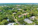 A lovely home is nestled amongst trees and other houses within a quiet neighborhood, with mature landscaping all around at 2504 Mulberry Ter, Sarasota, FL 34239