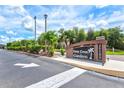 Community sign for Deep Creek Gardens with lush landscaping and clear skies at 25100 Sandhill Blvd # 104 G, Punta Gorda, FL 33983
