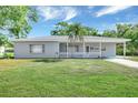 Charming single-story home with a spacious front yard and a welcoming covered porch on a sunny day at 2622 11Th W Ave, Bradenton, FL 34205