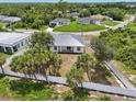 An aerial shot of the home, lush landscaping, fenced yard, and neighborhood at 2794 Escambia Cir, North Port, FL 34288
