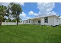 An ample backyard with healthy lawn, white fencing, and a covered lanai at 2794 Escambia Cir, North Port, FL 34288
