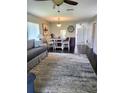Inviting living room featuring dark wood floors, an area rug, and an adjacent dining area with natural light at 3305 Notre Dame Pl # 3305, Bradenton, FL 34207