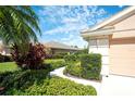 Well-manicured lawn and lush landscaping with healthy green plants surrounding the home create a serene curb appeal at 362 Fairway Isles Ln, Bradenton, FL 34212