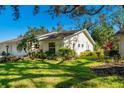 Side of the villa showcasing the well-maintained landscaping and verdant lawn on a sunny day at 4279 Oakhurst E Cir # 3044, Sarasota, FL 34233