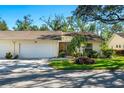 Villa's exterior with a two-car garage, neat landscaping, and charming curb appeal at 4279 Oakhurst E Cir # 3044, Sarasota, FL 34233