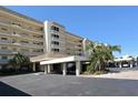 Exterior view of the building featuring a covered parking area and manicured landscaping at 4325 Gulf Of Mexico Dr # 204, Longboat Key, FL 34228