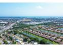 Beautiful aerial view of the community featuring lakes, tree lined streets, and Sarasota Bay in the distance at 5863 Cavano Dr, Sarasota, FL 34231