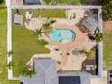 Aerial view of backyard with a kidney-shaped pool with tropical landscaping, outdoor seating and white fence at 6178 Coliseum Blvd, Port Charlotte, FL 33981