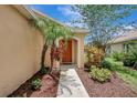 Inviting front entrance showcasing a well-maintained walkway framed by lush tropical plants and mulch at 6352 Robin Cv, Lakewood Ranch, FL 34202
