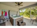 Well-appointed sunroom with a luxurious hot tub, ceiling fan, and access to the outdoors at 640 Encarnacion St, Punta Gorda, FL 33983
